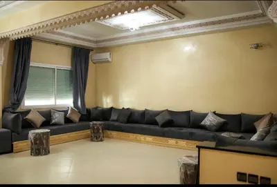 a living room with a black couch and a window at Fes apartment in Fès