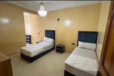 a bedroom with two beds and a chandelier at Fes apartment in Fès