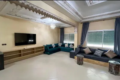 a living room with couches and a flat screen tv at Fes apartment in Fès
