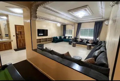 a large living room with a couch and a television at Fes apartment in Fès