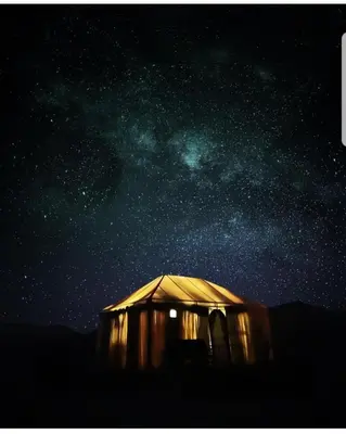 a tent under a starry sky with the milky way at Merzouga Activities Camp in Merzouga