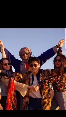 a group of people standing together with their arms in the air at Merzouga Activities Camp in Merzouga