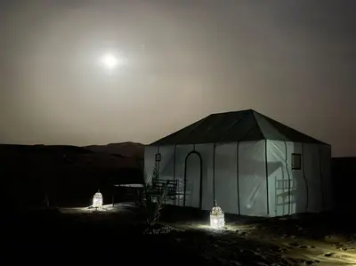a tent in the middle of the desert at night at Merzouga Activities Camp in Merzouga