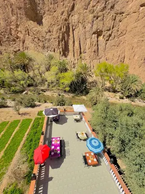 an aerial view of a patio with tables and umbrellas at Hotel De La Vallée in Aït Baha