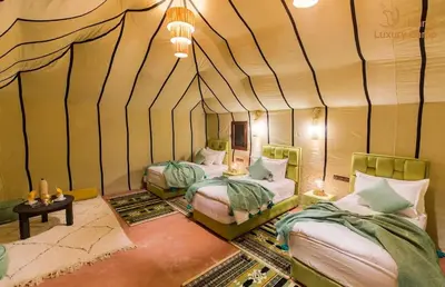 a room with two beds in a tent at Merzouga Hamza Luxury Camp in Merzouga