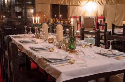 a long table with a white table cloth on it at Merzouga Hamza Luxury Camp in Merzouga