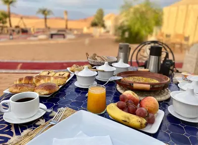 a blue table with breakfast foods and drinks on it at Merzouga Hamza Luxury Camp in Merzouga