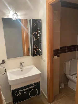 a bathroom with a sink and a mirror and a toilet at Bel appartement meublé avec Wifi fibre optique in Fès