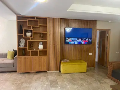a living room with a couch and a flat screen tv at Bel appartement meublé avec Wifi fibre optique in Fès