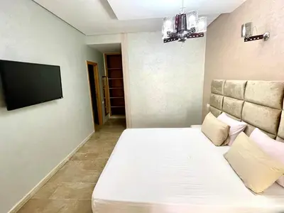 a bedroom with a bed and a flat screen tv at Bel appartement meublé avec Wifi fibre optique in Fès