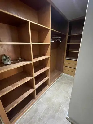 a walk in closet with wooden shelves at Bel appartement meublé avec Wifi fibre optique in Fès