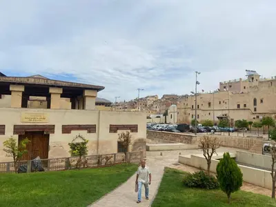 a man walking down a sidewalk in front of a building at Dar Lalla Yedouna Chez Charifa in Fès