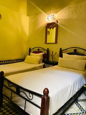 two beds in a room with yellow walls at Dar Lalla Yedouna Chez Charifa in Fès
