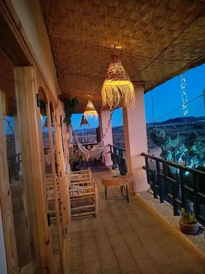 a room with a hammock and a balcony with a view at CHÂTELET Ouarzazate in Tabount
