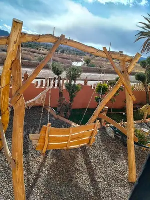 a wooden swing hanging from a wooden post at CHÂTELET Ouarzazate in Tabount