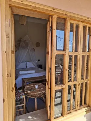 a wooden room with a bed and a table at CHÂTELET Ouarzazate in Tabount