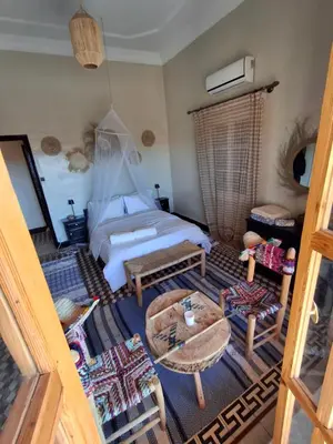 an aerial view of a bedroom with a bed and a table at CHÂTELET Ouarzazate in Tabount