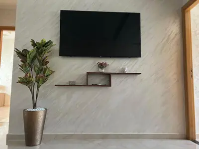 a television on a wall with a vase with a plant at Appartement luxueux à Fès in Douar Oulad Mhammed