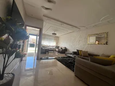 a large living room with a couch and a table at Appartement luxueux à Fès in Douar Oulad Mhammed