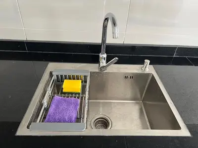 a kitchen sink with a purple sponge and a faucet at Appartement luxueux à Fès in Douar Oulad Mhammed