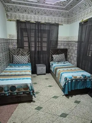 a bedroom with two beds and a ceiling at Apparemment familiale 110 m2 in MeknèsKatine