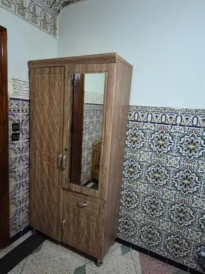 a wooden cabinet with a mirror in a room at Apparemment familiale 110 m2 in MeknèsKatine