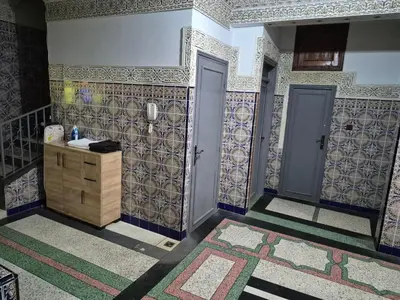 a bathroom with tiles on the walls and two doors at Apparemment familiale 110 m2 in MeknèsKatine