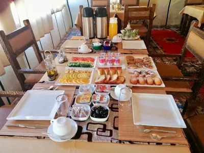 a table with several trays of different types of pastries at Anir Luxury Camp - Gites et Tentes de Luxe in Merzouga