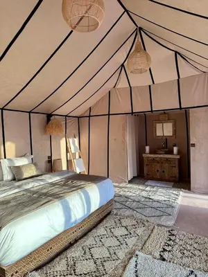 a bedroom with a bed in a tent at Anir Luxury Camp - Gites et Tentes de Luxe in Merzouga