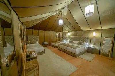 a bedroom with two beds in a room with a ceiling at Anir Luxury Camp - Gites et Tentes de Luxe in Merzouga