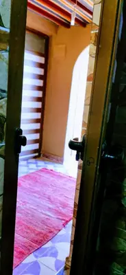 an open door to a hallway with a red rug at Ali Baba Desert Camp in El Gouera
