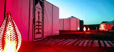 a building with red lights and a christmas tree at Ali Baba Desert Camp in El Gouera