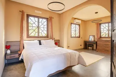 a bedroom with a large white bed and windows at Villa wafai in Srarhna