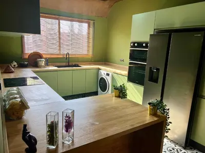 a kitchen with green cabinets and a wooden counter top at Villa wafai in Srarhna