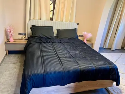 a bedroom with a large bed with a blue comforter at Villa wafai in Srarhna