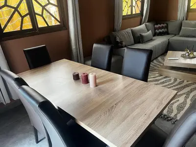 a dining room with a wooden table and chairs at Villa wafai in Srarhna