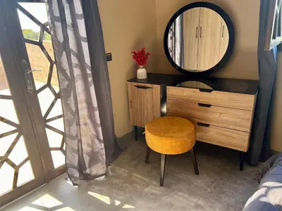 a vanity with a mirror and a chair in a room at Villa wafai in Srarhna