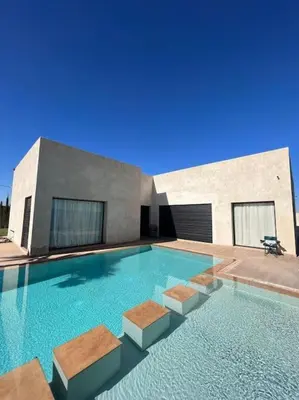 a large swimming pool in front of a building at Villa Mia, Piscine chauffée, parking,Iptv in Najem