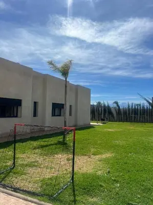 a net in front of a building with a palm tree at Villa Mia, Piscine chauffée, parking,Iptv in Najem