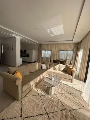 a living room with a large couch and a table at Villa Mia, Piscine chauffée, parking,Iptv in Najem