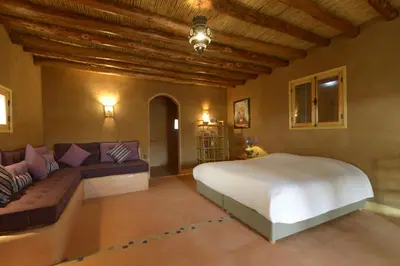 a bedroom with a large bed and a couch at Guest farm Oulad Chmicha in Bir el Kelb