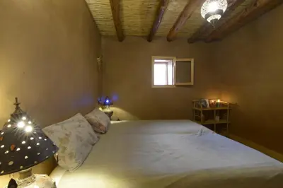 a bedroom with a large bed with a window at Guest farm Oulad Chmicha in Bir el Kelb