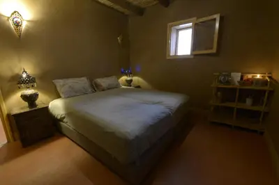a bedroom with a large bed with a window at Guest farm Oulad Chmicha in Bir el Kelb