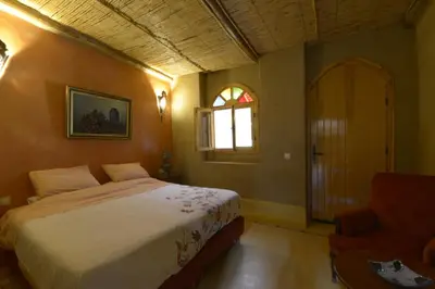 a bedroom with a bed and a window and a chair at Guest farm Oulad Chmicha in Bir el Kelb