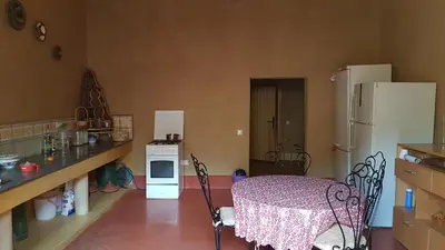 a kitchen with a table and a white refrigerator at Guest farm Oulad Chmicha in Bir el Kelb