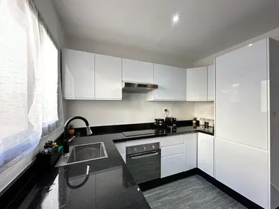 a kitchen with white cabinets and a sink at Appartement Moderne & Cosy in Fès