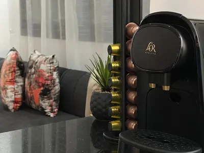a coffee machine sitting on a table next to a couch at Appartement Moderne & Cosy in Fès