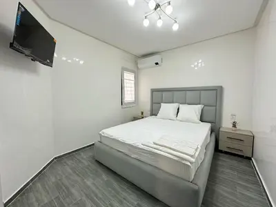 a bedroom with a bed and a flat screen tv at Appartement Moderne & Cosy in Fès