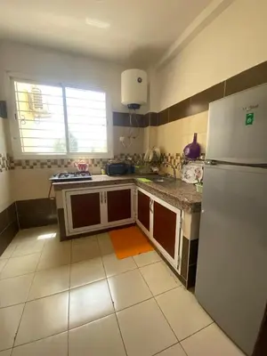 a kitchen with a white refrigerator and a tile floor at Marwan's apartment 2 in Ifrane