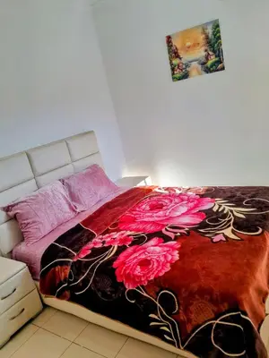 a bedroom with a bed with a red and black blanket at Marwan's apartment 2 in Ifrane